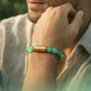 A man wearing a Magnet Green Aventurine Bracelet showcasing its green aventurine beads and magnetic component.