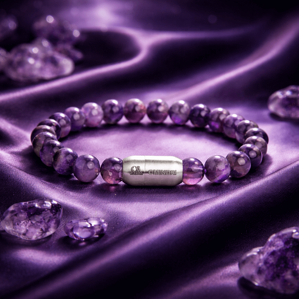 Magnet Amethyst Bracelet displayed on a soft purple surface with natural amethyst gemstone beads and a sleek silver centerpiece.