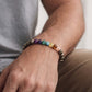 Magnet 7 Chakra With Pyrite Bracelet worn on a man's wrist, showcasing colorful chakra stones and pyrite.